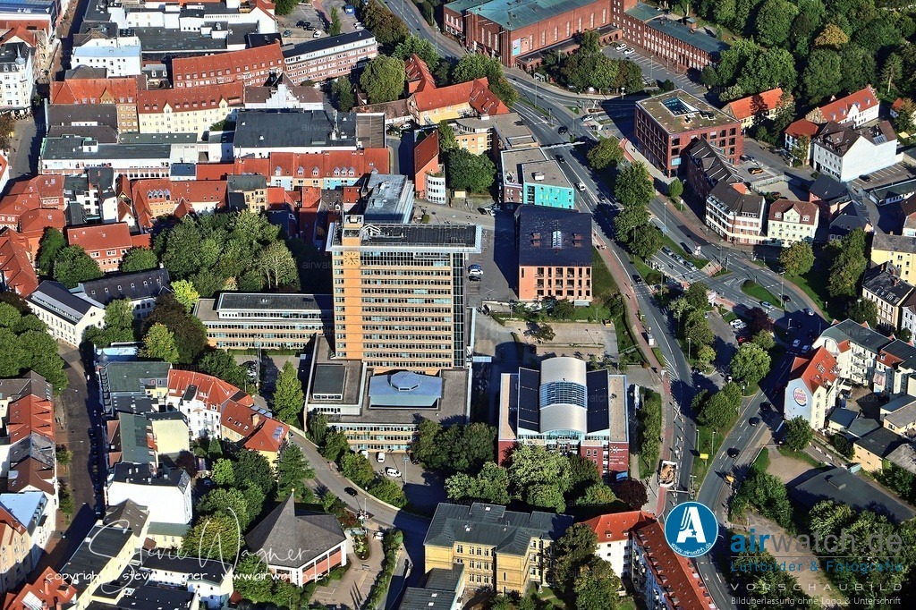 Luftbild Flensburg, Rathausplatz, Deutsches Haus, St.Nikolei-Kirche | Das Rathaus, ein modernes Hochhaus mit siebzehn Stockwerken, wurde von Architekt Carl-Friedrich Fischer entworfen und 1965 offiziell in Betrieb genommen. Es beherbergt die Ratsversammlung, den Oberbürgermeister und große Teile der Stadtverwaltung, sowie seit 2008 auch die Verwaltungsgeschäfte von Glücksburg.