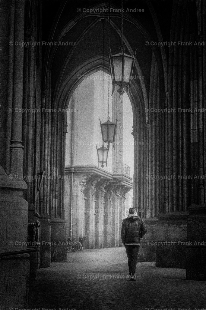Erfurt | Ein Mann geht allein durch eine Arkade in der schönen Altstadt von Erfurt in Thüringen. Es ist ein nebliger Tag. Fine art Straßenfotografie in schwarz und weiß. - Realisiert mit Pictrs.com