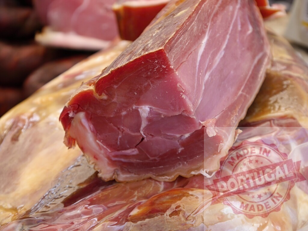 Dry-cured ham displaying pink meat and white fat texture | Dry-cured ham sliced, revealing its texture and rich color, ready for consumption - Realisiert mit Pictrs.com