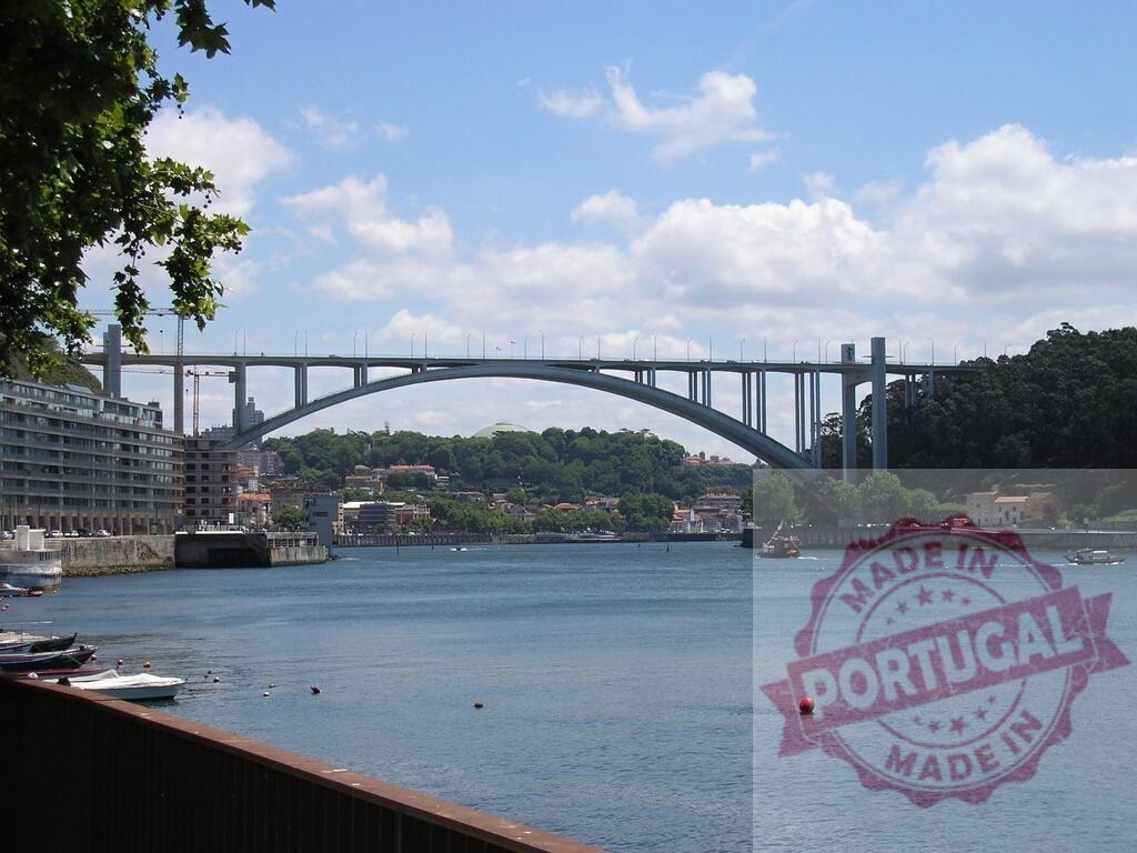 Ponte da Arrábida arch bridge spanning Douro River in Porto Portugal | Arrábida bridge crossing the Douro River with city buildings and blue sky - Realisiert mit Pictrs.com