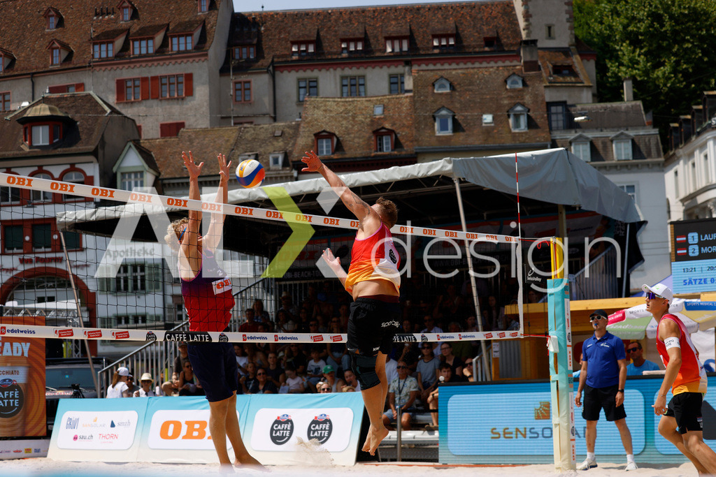 Obi BeachTour 2026 - Basel | BASEL, SWITZERLAND - JULY 19: MORITZ KINDL (AUT) attack / spike against MATHIS KÄLIN (SUI) block during the Obi BeachTour 2026 match between LEITNER / KINDL (AUT) and BREER / KÄLIN (SUI) at Barfüsserplatz on July 19, 2026 in Basel, Switzerland. - Realisiert mit Pictrs.com