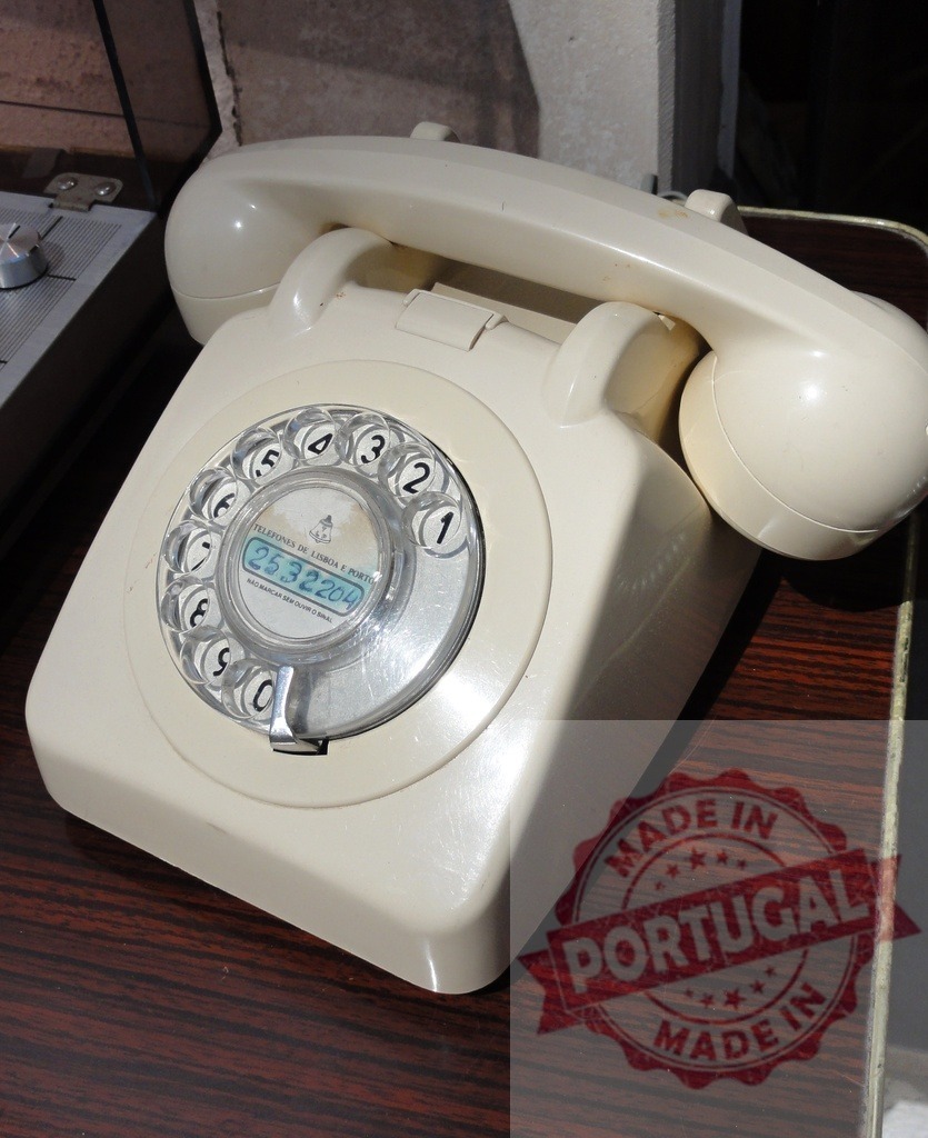 Vintage white rotary phone resting on a wooden surface | Old white rotary phone with visible number displaying 2532204, resting on a wooden surface - Realisiert mit Pictrs.com