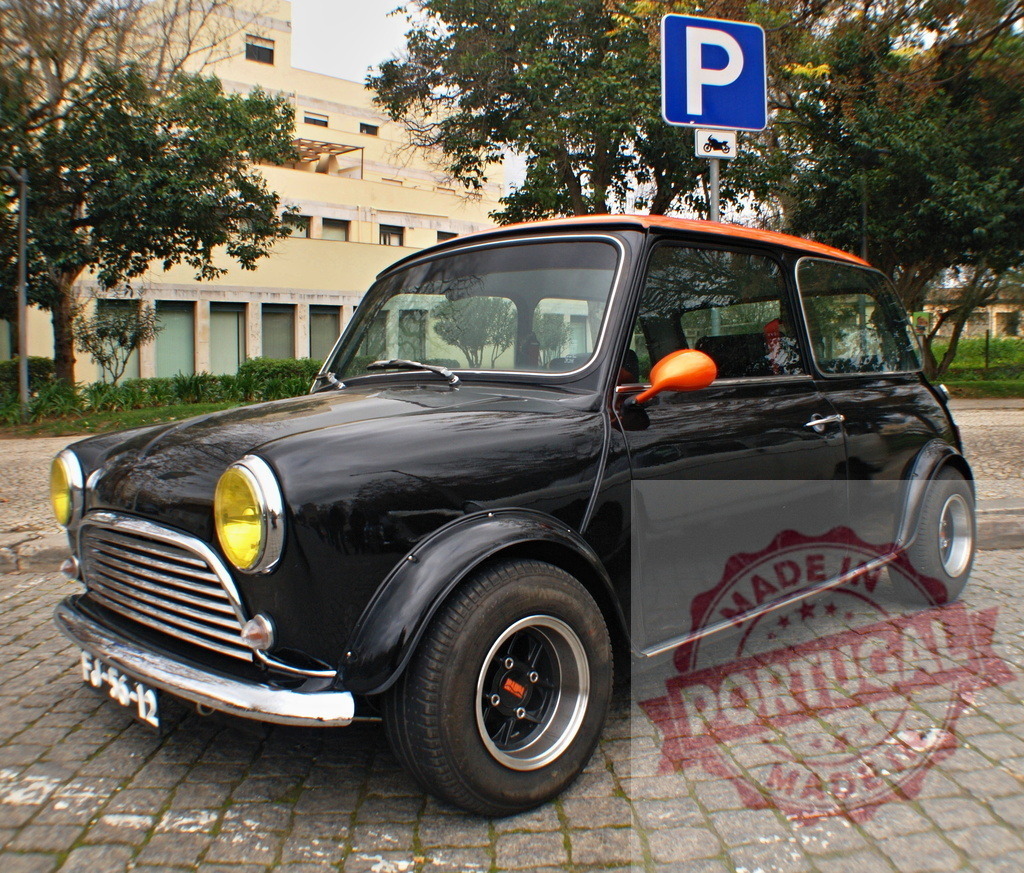 Classic Mini Cooper parking near parking sign | Customized black Mini Cooper with orange accents parked near a parking sign - Realisiert mit Pictrs.com