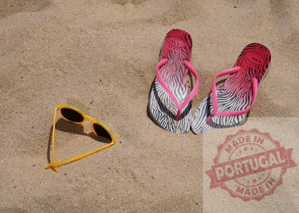 Flip-flops and sunglasses on sandy beach | Colorful flip-flops and yellow sunglasses resting on golden sand, symbolizing summer vacation - Realized with Pictrs.com