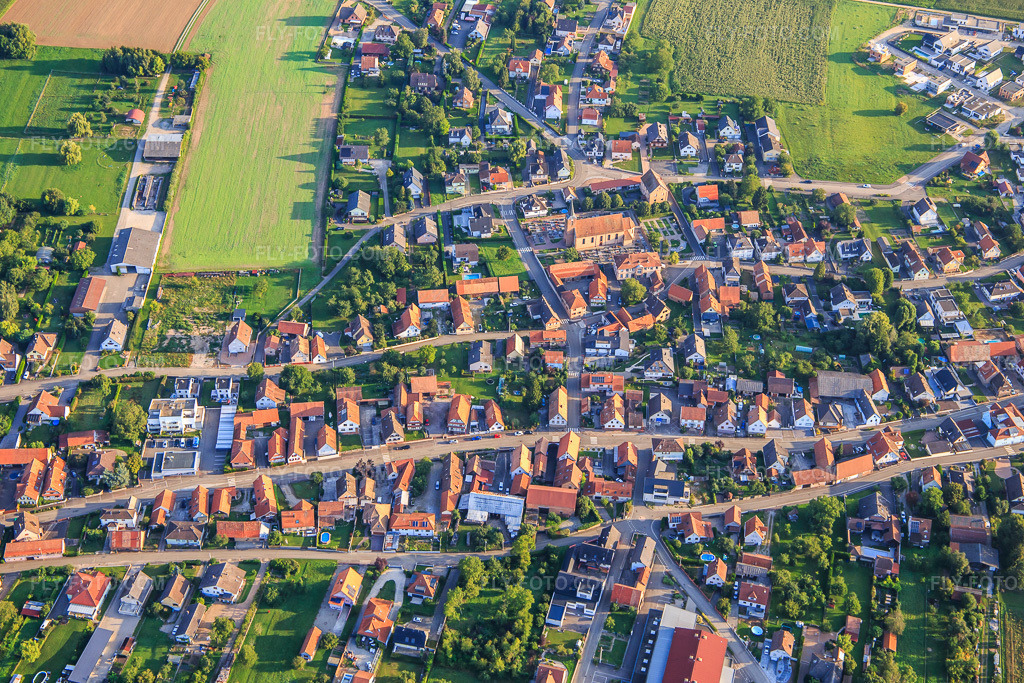 Aerial view: Village overview from the south in Eschbach in the state Bas-Rhin, France. – Photo: IMG_138078.jpg taken on 08/19/2023 by Werner Riehm/FLY-FOTO.com – Resolution of the original: 5355 x 3570 px