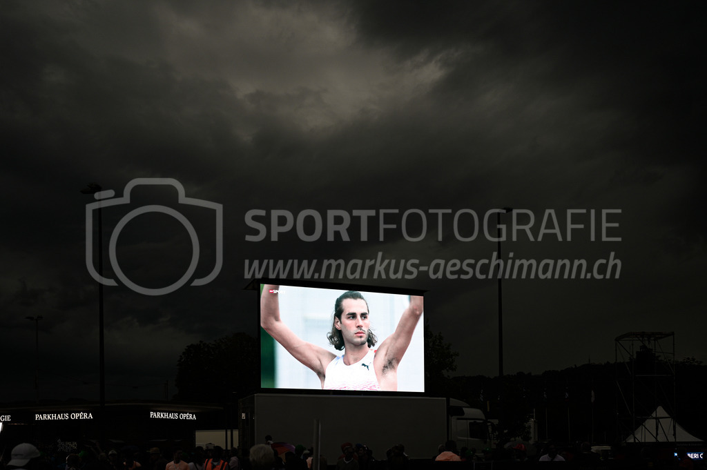 Leichtathletik: Weltklasse Zürich | 07.09.2022, Zürich, Sechseläutenplatz, Leichtathletik: Weltklasse Zürich, TAMBERI Gianmarco (ITA) im Hochsprung der Männer auf der Grossleinwand vor dem dramatischen Gewitterhimmel. - Realisiert mit Pictrs.com
