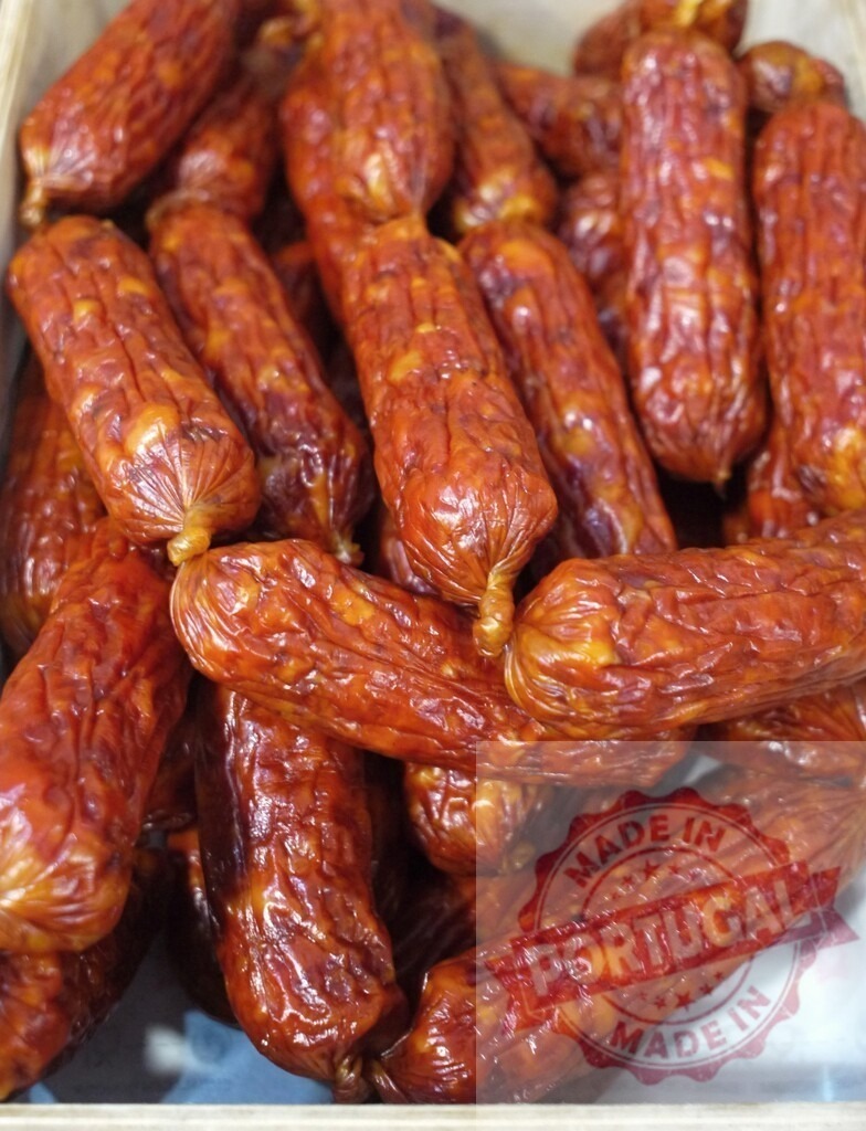Smoked sausages displaying traditional pork meat products | Pile of small smoked sausages offering a savory snack or deli item - Realisiert mit Pictrs.com