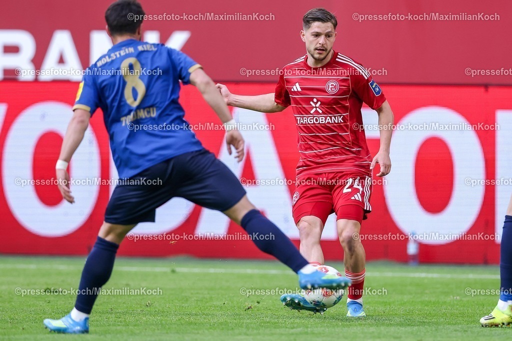 F9510042601027 | 10.04.2026, Fußball, Fortuna Düsseldorf - Holstein Kiel, 2. Fußball Bundesliga, Herren, Merkur Spiel-Arena, 29. Spieltag, Saison 2025 2026: Umut Tohumcu&nbsp; (Holstein Kiel #08) im Zweikampf gegen  Florent Muslija&nbsp;(Fortuna Düsseldorf #24)  DFB regulations prohibit any use of photographs as image sequences and or quasi-video.