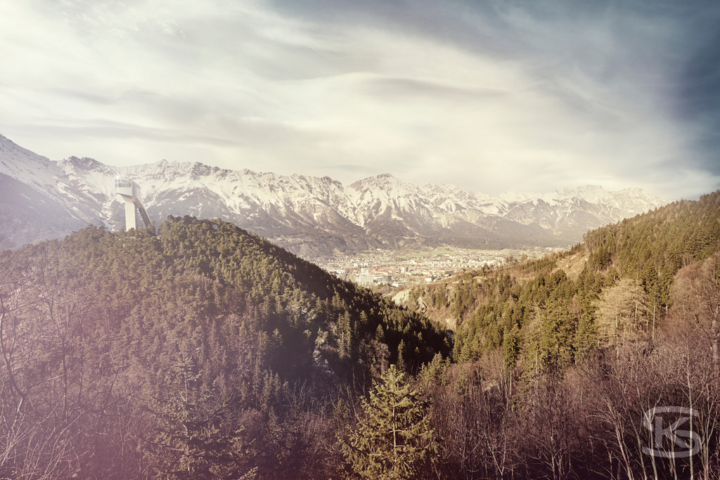 Innsbrucker Bergisel Skischanze und Nordkette Panorama | Genießen Sie den atemberaubenden Blick auf die Olympiastadt Innsbruck und die umliegende Bergwelt. Die berühmte, von Zaha Hadid entworfene, architektonisch einzigartige Bergiselschanze überragt die Stadt und bietet eine fantastische Aussichtsplattform auf die schneebedeckte Nordkette. - Realisiert mit Pictrs.com
