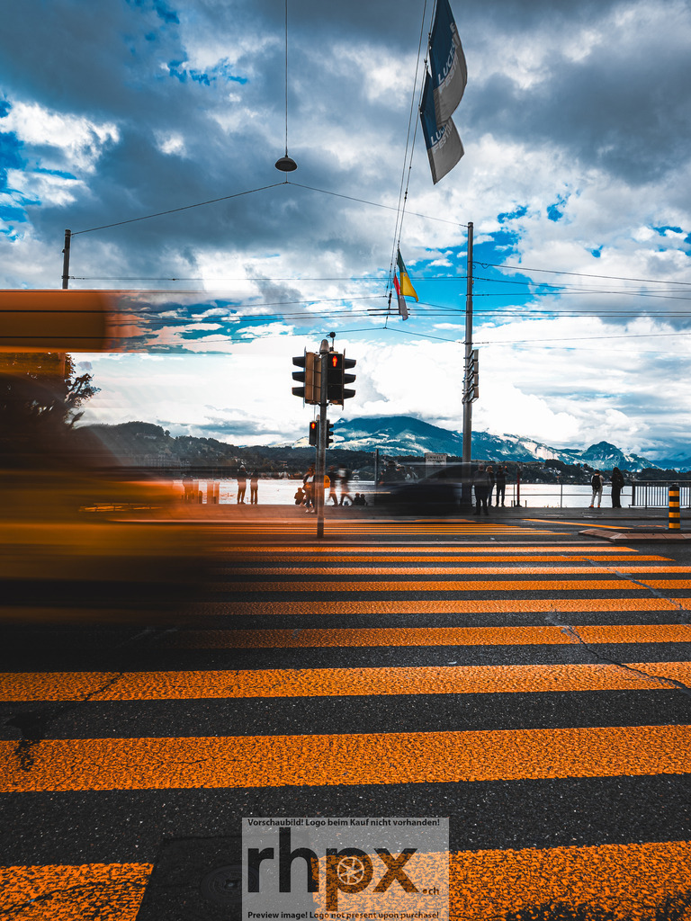 Urbaner Puls auf der Seebrücke Luzern | <p><strong>Dynamik. Bewegung. Alltag.</strong></p> <p>Die Seebrücke als pulsierende Ader Luzerns, eingefangen in einem Moment flüchtiger Energie. Zwischen dem markanten KKL und den fernen Berggipfeln verschmelzen Passanten und Verkehr zu einer kunstvollen Spur aus Bewegung und Licht.</p> <p>Wähle unter "Produktauswahl" dein Wunschformat: Vom klassischen Wandbild über Puzzle & Tassen bis zum digitalen Download (z.B. als Handy-Hintergrund).</p> - Realisiert mit Pictrs.com