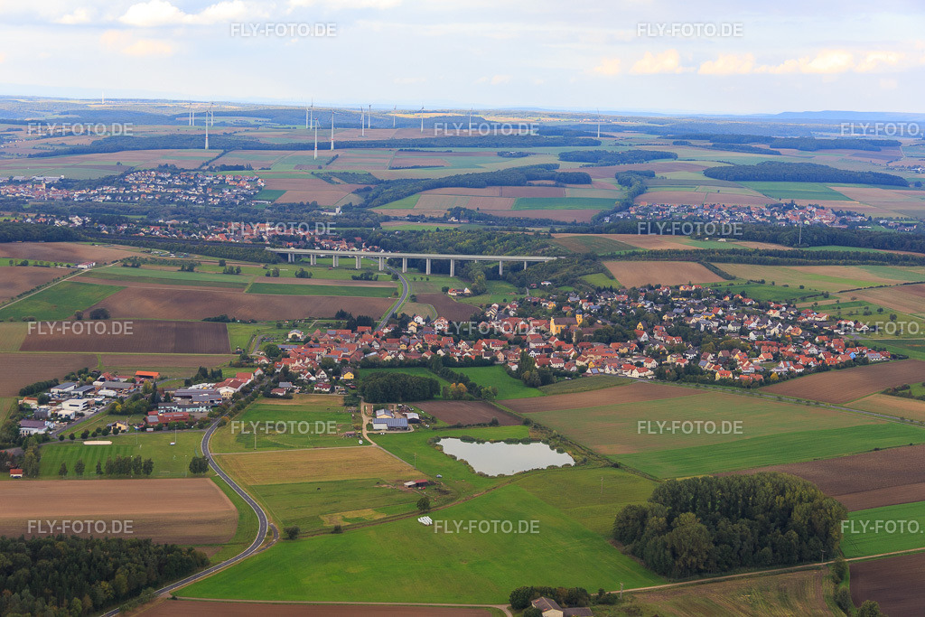 Talbrücker der A70 hinter dem Dorf mt St. Laurentius Obereuerheim und Schloß Euerburg und https://www.pfarramt-obereuerheim.de/ | Luftbild: Talbrücker der A70 hinter dem Dorf mt St. Laurentius Obereuerheim und Schloß Euerburg und https://www.pfarramt-obereuerheim.de/ im Ortsteil Obereuerheim in Grettstadt im Bundesland Bayern in Deutschland. Foto: IMG_073856.jpg vom 27.09.2014 durch Werner Riehm/FLY-FOTO.de - Realisiert mit Pictrs.com