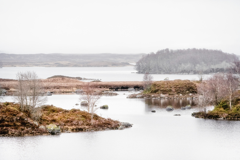 Loch Ba im Winternebel, Schottland | Loch Bà ist ein schottischer Süßwassersee im Rannoch Moor in der Council Area Highland. Der See hat eine sehr unregelmäßige Form und zahlreiche Inseln.https://de.wikipedia.org/wiki/Loch_B%C3%A0Eine weite Winterlandschaft am Loch Ba in Schottland zeigt einen ruhigen See, der von kleinen Inseln und Ufern mit karger Vegetation umgeben ist. Die Szene ist von einem nebligen, hochhellen Licht durchdrungen, das eine gedämpfte Farbpalette aus Braun-, Grau- und Weißtönen erzeugt und die entfernten Hügel weich verschwimmen lässt. - Realisiert mit Pictrs.com