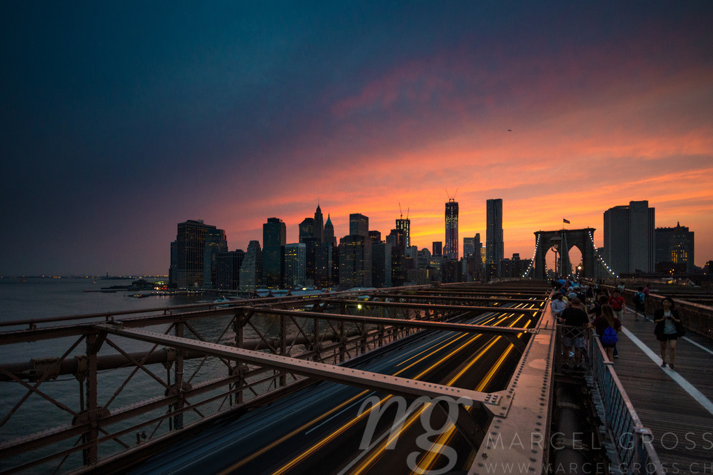 Manhatten Sunset seen from Brooklyn Bridge | a longexposure capture at Brooklyn Bridge with lighttrails of the passing cars and the world famous silhouette of Manhatten - Realisiert mit Pictrs.com