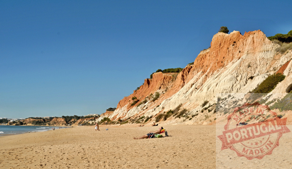 Praia da Falésia beach with colorful cliffs and sunbathers | Sandy beach with vibrant cliffs along the Atlantic Ocean in Algarve, Portugal - Realized with Pictrs.com