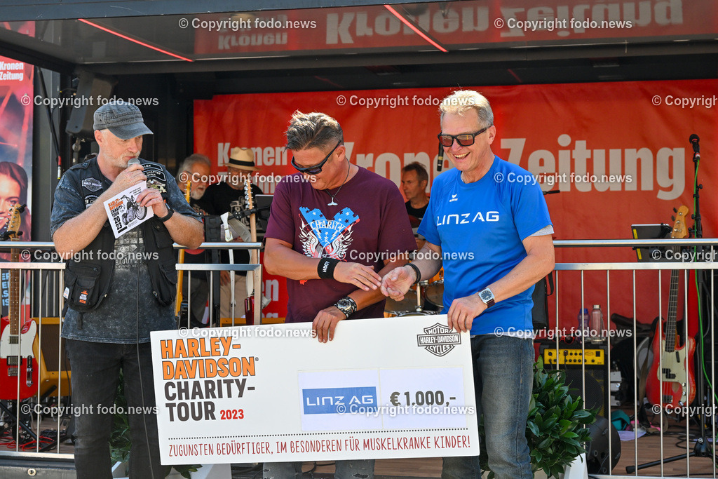 Linz_ Harley Davidson Charity_ 15.08.2023-45 | 15.08.2023, Linz, AUT, Harley Davidson Charity 2023 Hauptplatz Linz, im Bild Moderator,
Didi Baier (Praesident Harley Davidson),  Hans Frisch (Harley Davidson Upper Austria Chapter) mit einem Scheck der Linz AG