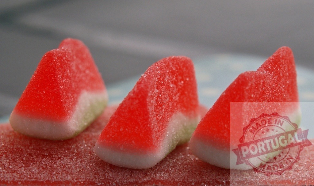 Watermelon slice gummy candy on sugary red background | Watermelon slice gummy candies with sugar coating on a sweet red surface - Realisiert mit Pictrs.com