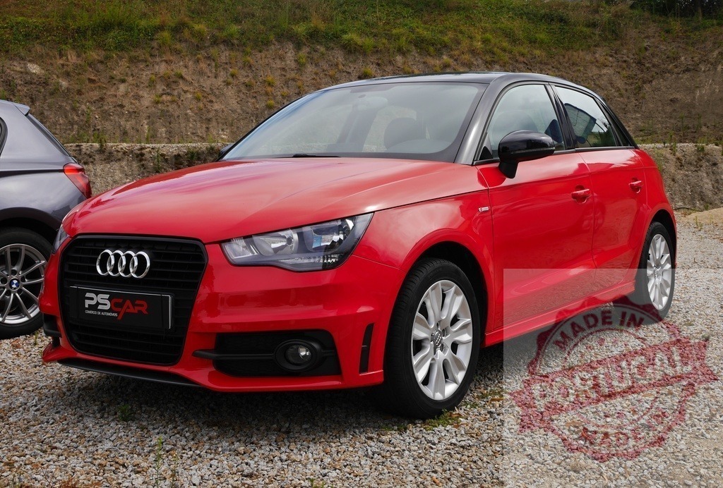 Red Audi A1 Sportback parked on gravel lot outdoors | Red Audi A1 Sportback standing on a gravel parking lot, presenting modern transportation - Realisiert mit Pictrs.com