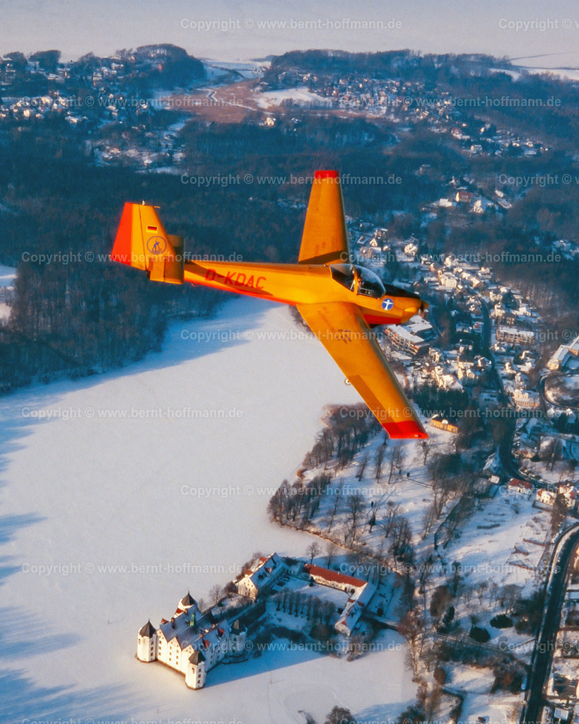 PLBDD_CFalke_Glbg-Schloss_80x100 | Luftbild. Schneelandschaft am Glücksburger Schloss. Der Motorsegler ( Typ Scheibe C-FALKE SF 25 ) überfliegt den zugefrorenen Schlossteich. ___ Das Foto ist eine Reproduktion von einem Farbdia. - Realisiert mit Pictrs.com