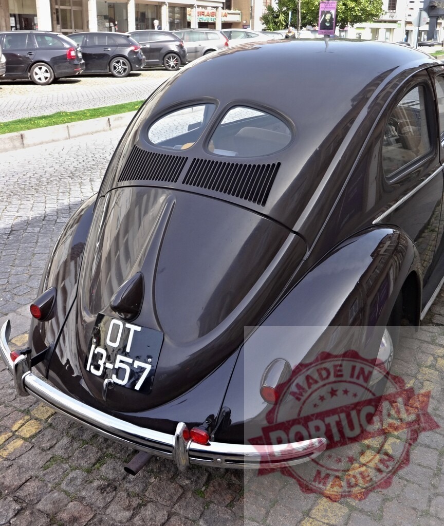 Rear view of parked dark brown Volkswagen Beetle showing oval back window | Classic Volkswagen Beetle parked on cobblestone street, showcasing its unique oval rear window and dark brown paint - Realisiert mit Pictrs.com