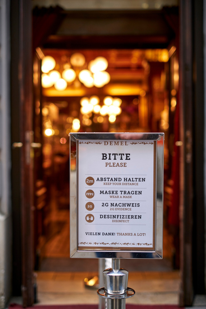 Eingang in die K. u. K. Hofzuckerbäckerei Demel mit Hinweis | Wien, Austria - November 22, 2021: Eingang in die K. u. K. Hofzuckerbäckerei Demel mit Hinweis auf die Covid Massnahmen. - Realisiert mit Pictrs.com