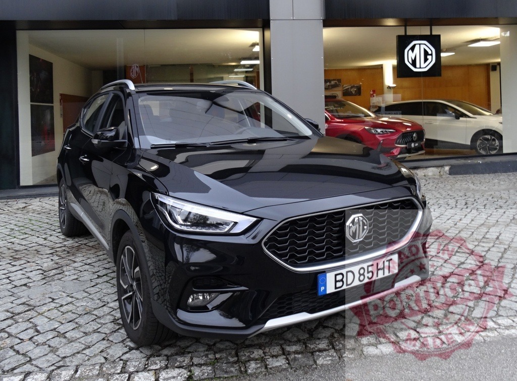 Black MG ZS crossover parked at dealership | MG ZS crossover parked on cobblestone outside a car dealership - Realisiert mit Pictrs.com
