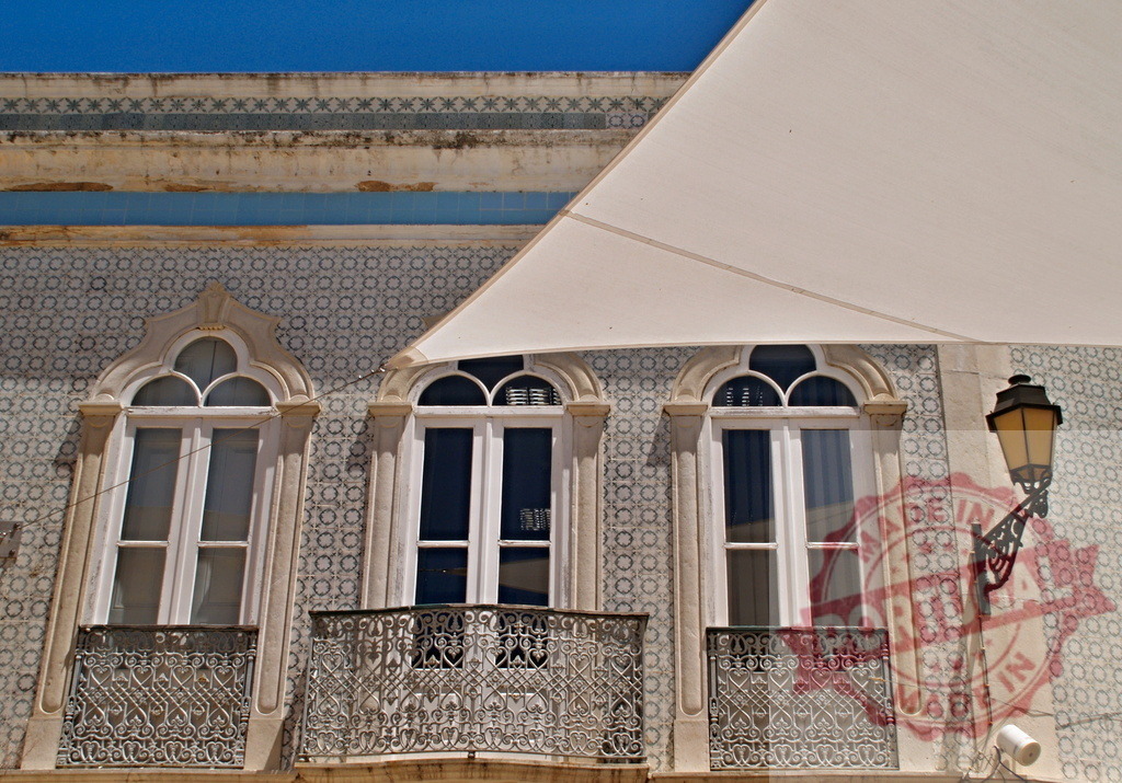 Portugal building facade with azulejo tiles and balconies | Ornate azulejo facade of a traditional Portuguese building with decorative windows and balconies - Realized with Pictrs.com