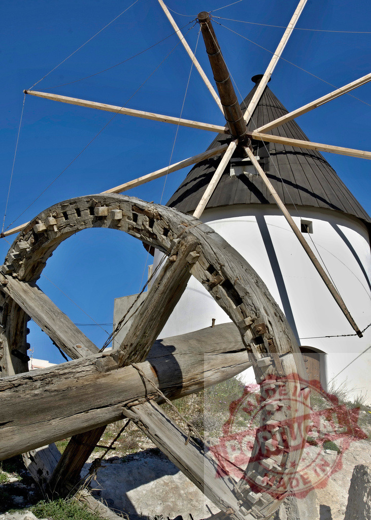 Traditional Greek windmill with old wooden gear mechanism | Abandoned old wooden gear from a traditional Greek windmill against blue sky - Realisiert mit Pictrs.com