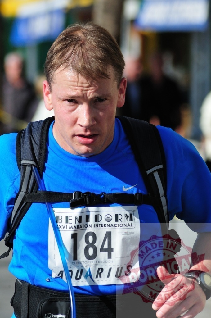 Athlete running Benidorm International Marathon wearing blue shirt | Male athlete running Benidorm International Marathon wearing blue t-shirt with race number - Realisiert mit Pictrs.com