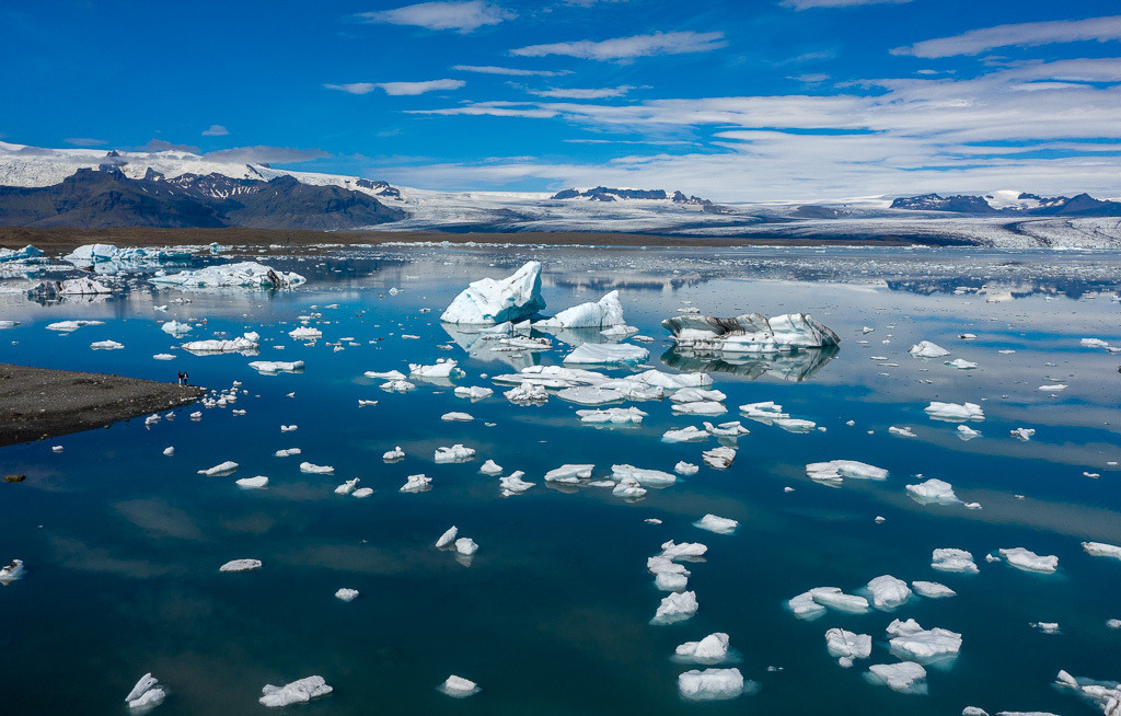 island-DJI_0566 | Jökulsárlón ist eine Gletscherlagune, die an den Nationalpark Vatnajökull im Südosten Islands angrenzt. Im Wasser schwimmen unzählige Eisberge des Vatnajökull-Gletschers, dessen Ausläufer im Hintergrund zu sehen ist. - Realisiert mit Pictrs.com