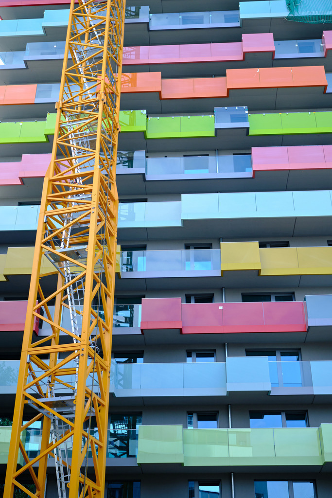 Vorderansicht Neubau mit bunten Balkonen | Wien, Austria - August 20, 2024: Vorderansicht einer Neubau-Wohnung mit bunten Balkonen und Hochkran. - Realisiert mit Pictrs.com