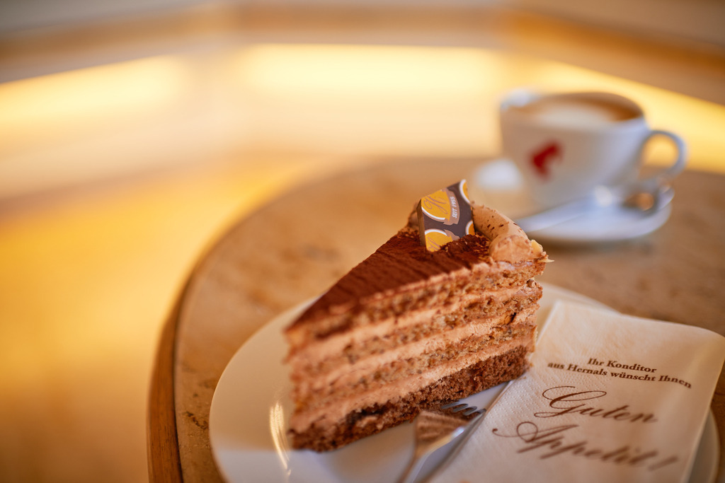 Cafe Hübler | Wien, Austria - January 16, 2019: Cafe Hübler; eine Hüblertorte mit Melange steht auf dem Tisch im Verkaufsraum. - Realisiert mit Pictrs.com
