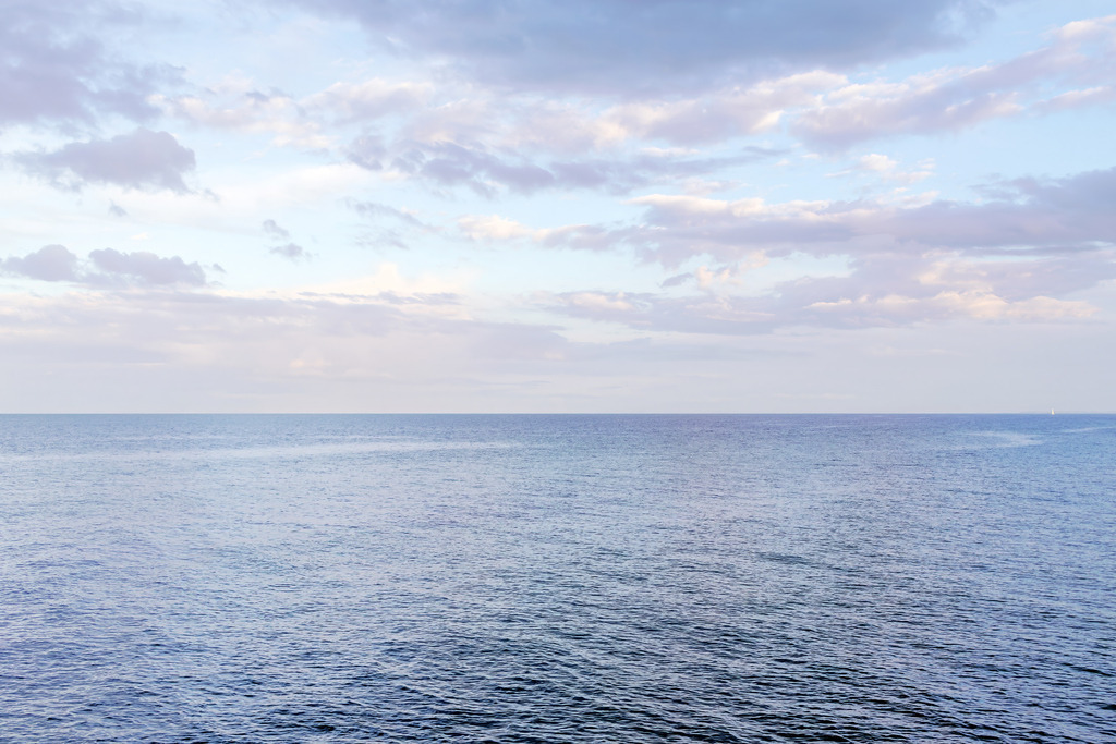 Maritime Stimmung im Abendlicht – Sanfte Weite am Meer | Dieses Motiv zeigt die ruhige Weite des Meeres unter einem sanften Abendhimmel. Zarte Wolkenstrukturen ziehen über die Horizontlinie, während das warme Licht des Abends die Wasseroberfläche in weichen Blau‑ und Lilatönen schimmern lässt. Die klare, offene Komposition vermittelt ein Gefühl von Stille, Leichtigkeit und maritimer Weite. Als Wandbild erhältlich auf Acrylglas und weiteren hochwertigen Materialien.