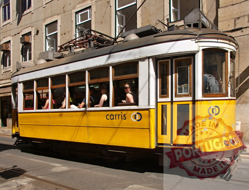 Yellow Lisbon Tram carrying tourists in Alfama district | Passengers enjoying a ride on a vintage yellow tram in Lisbon, Portugal - Realized with Pictrs.com