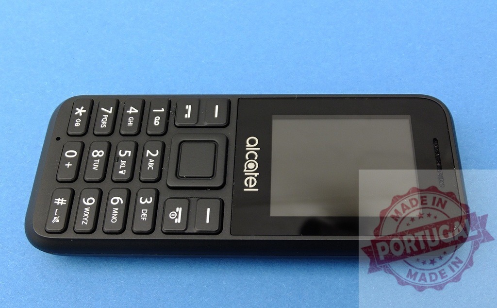 Alcatel mobile phone showing keypad and screen on blue background | Classic black Alcatel mobile phone with keypad and screen on a blue background, highlighting its simple design - Realized with Pictrs.com