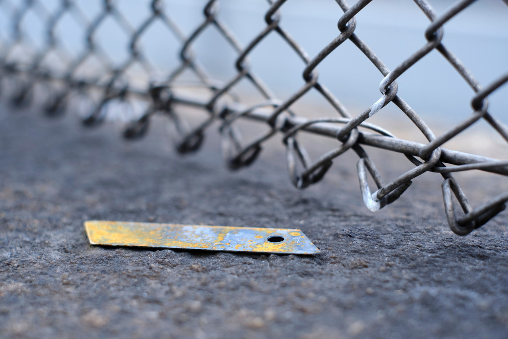 rostige Messerklinge auf einer Mauer liegend | Wien, Austria - November 22, 2021: rostige Messerklinge auf einer Mauer liegend, dahinter ein Drahtzaun. - Realisiert mit Pictrs.com