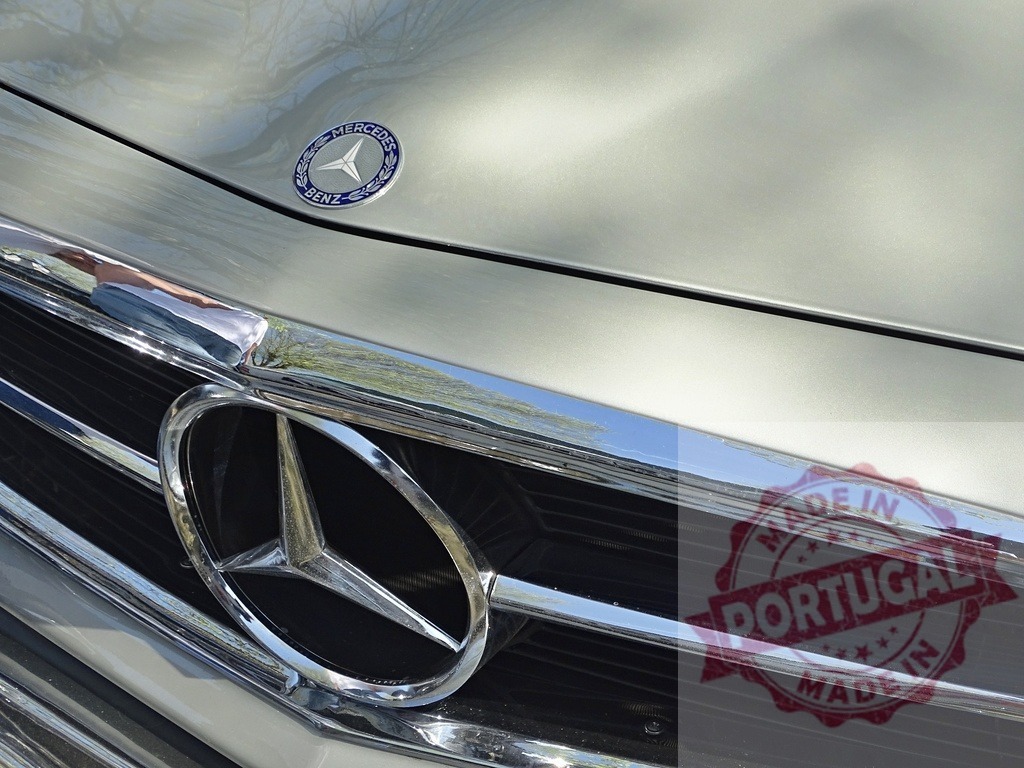Mercedes-Benz emblem and grille on luxury car | Mercedes-Benz logo and grille reflecting light on a car's hood - Realized with Pictrs.com