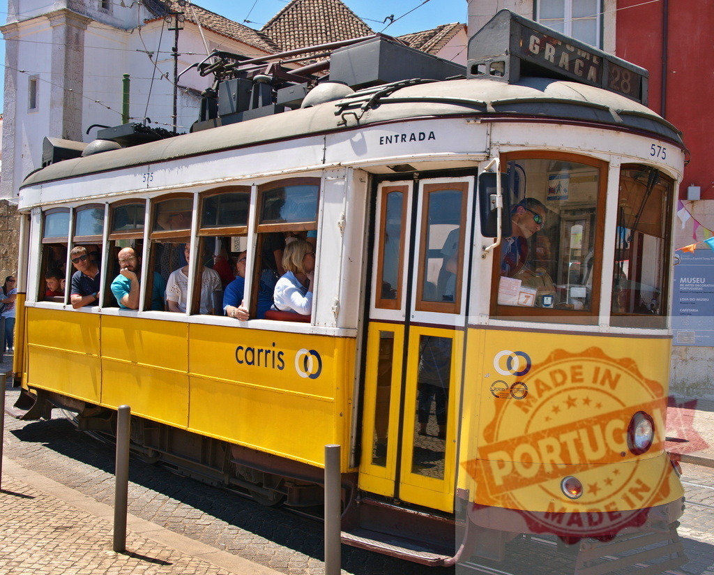 Yellow Lisbon tramway carrying tourists in Alfama district | Passengers enjoying a ride on a vintage yellow Carris tram in Lisbon, Portugal - Realized with Pictrs.com