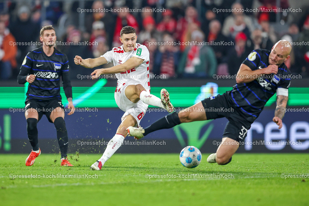 1FC04122401082 | 04.12.2024, Fußball, 1. FC Köln - Hertha BSC, Achtelfinale DFB-Pokal, RheinEnergieSTADION, Saison 2024 2025: Eric Martel (1.FC Köln #6) wird beim Schuss von Toni Leistner (Hertha #37) geblockt. ZweikampfDFB regulations prohibit any use of photographs as image sequences and or quasi-video.