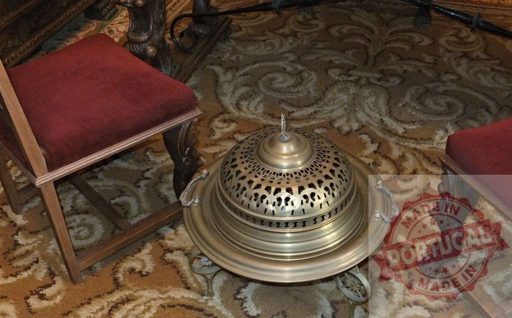 Ornate antique brass brazier on patterned carpet | Antique brass brazier sitting on a patterned carpet between two upholstered chairs - Realized with Pictrs.com