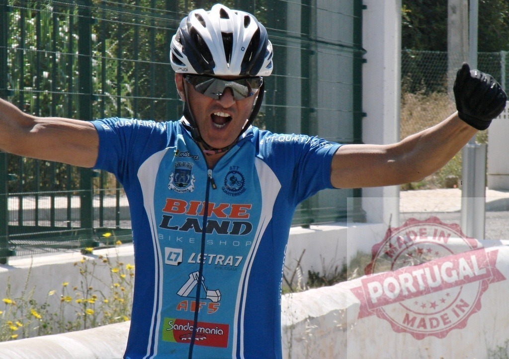 Cyclist celebrating victory with arms raised | Male cyclist wearing helmet and gloves celebrating his victory with arms raised - Realisiert mit Pictrs.com