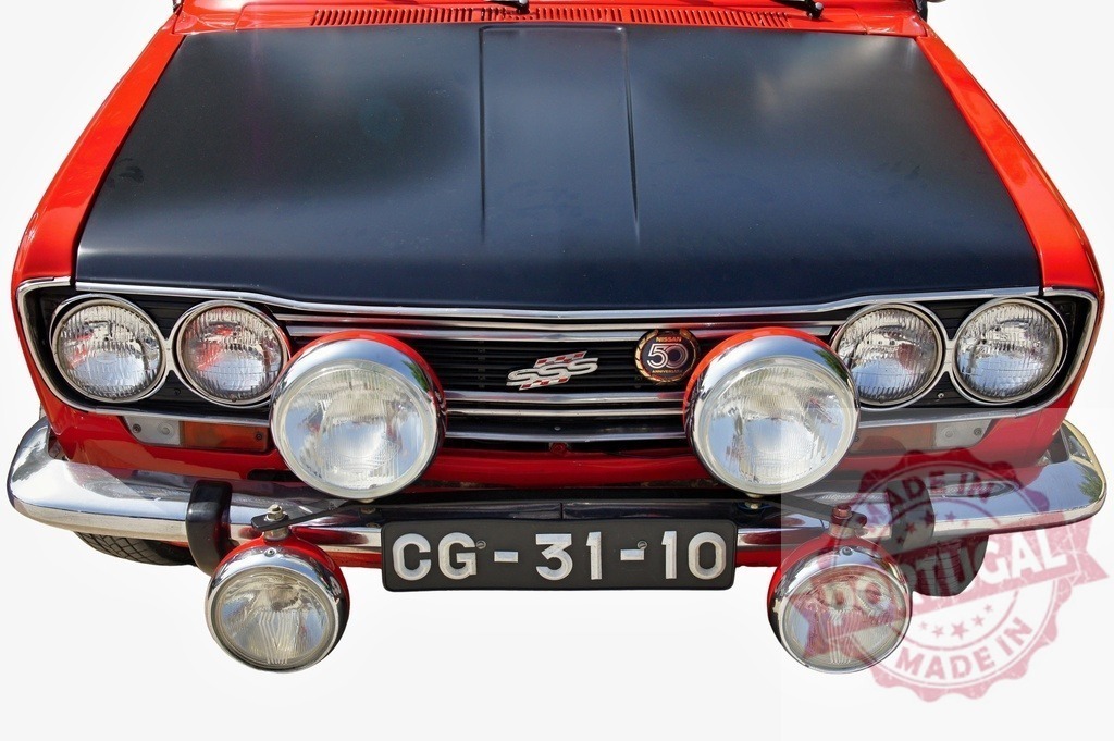 Datsun 510 rallying car front with auxiliary headlights | Front view of a classic red Datsun 510 SSS with a black hood and rally lights - Realized with Pictrs.com