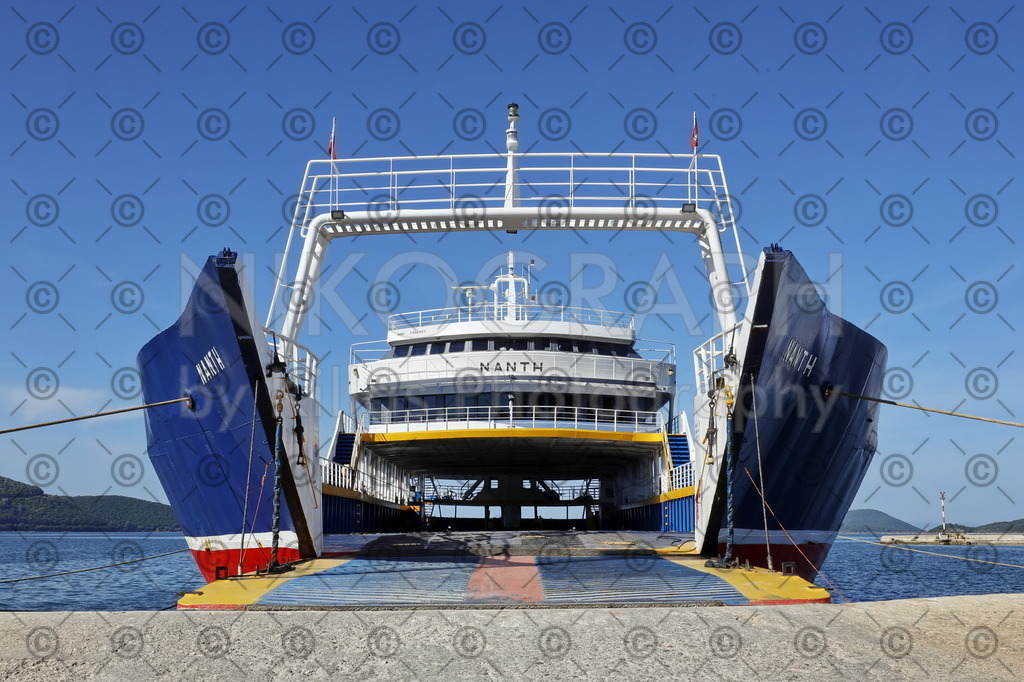 Ferry boat | Ein Bild der Fähre Nanti am Hafen von Igoumenitsa. Durch die heruntergelassene Fährrampe blickt man auf das Autodeck der Fähre. Die Fähre Nanti (NANTH) wurde 1973 in Griechenland gebaut und verbindet Igoumenitsa mit der ionischen Insel Korfu. Mit einer Länge von rund 66 Metern und einer Breite von ca. 12 Metern kann die Fähre ca. 105 Fahrzeuge transportieren. In Hintergrund des Fotos ist die Bucht von Igoumenitsa zu sehen. Die Fotografie ist beispielsweise als Leinwandbild, Jahreskalender oder Feinart-Print bestellbar.
