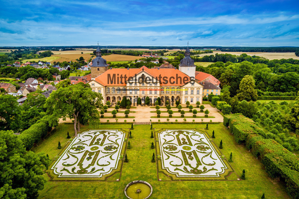 Barockschloss Hundisburg mit Garten bei Haldensleben-0020 | Dieses Luftbild zeigt das Schloss Hundisburg bei Haldensleben im Landkreis Börde in Sachsen-Anhalt an einem sonnigen Sommertag. Die eindrucksvolle Schlossanlage zählt zu den bedeutendsten Barockschlössern Norddeutschlands und gehört zu den bekanntesten Kulturdenkmalen des Landes. Aus der Vogelperspektive werden die harmonischen Proportionen des Schlosses und die weitläufigen Gartenanlagen besonders deutlich sichtbar.Besonders beeindruckend ist der historische Barockgarten, der zu den bedeutendsten Gartenanlagen Sachsen-Anhalts zählt. Die geometrisch angelegten Wege, Terrassen, Hecken und Sichtachsen spiegeln die Gestaltungsprinzipien der barocken Gartenkunst wider und verleihen dem Ensemble eine außergewöhnliche Eleganz. Im Sommer sorgen die gepflegten Grünflächen und die üppige Vegetation für ein besonders reizvolles Erscheinungsbild.Schloss Hundisburg blickt auf eine lange Geschichte zurück und entwickelte sich über Jahrhunderte zu einem bedeutenden kulturellen Zentrum der Region. Heute ist die Anlage ein beliebtes Ausflugsziel und Veranstaltungsort für Besucher aus ganz Deutschland.Dieses Luftbild zeigt Schloss Hundisburg und seinen berühmten Barockgarten in ihrer ganzen Schönheit und vermittelt einen eindrucksvollen Eindruck von Architektur, Gartenkunst und Kulturlandschaft in Sachsen-Anhalt. - Realisiert mit Pictrs.com