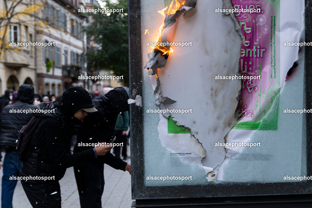 9L6A5640 | Strasbourg, France, 24 octobre 2026. Des manifestants affrontent les forces de l’ordre lors d’une mobilisation dans le centre-ville de Strasbourg. Des policiers interviennent pour disperser des groupes de manifestants, tandis que des gaz lacrymogènes sont utilisés. Des affrontements, des jets de projectiles et des dégradations sont observés dans plusieurs rues. Des barricades et des véhicules en feu témoignent de la tension qui règne en marge de la mobilisation. - Realisiert mit Pictrs.com