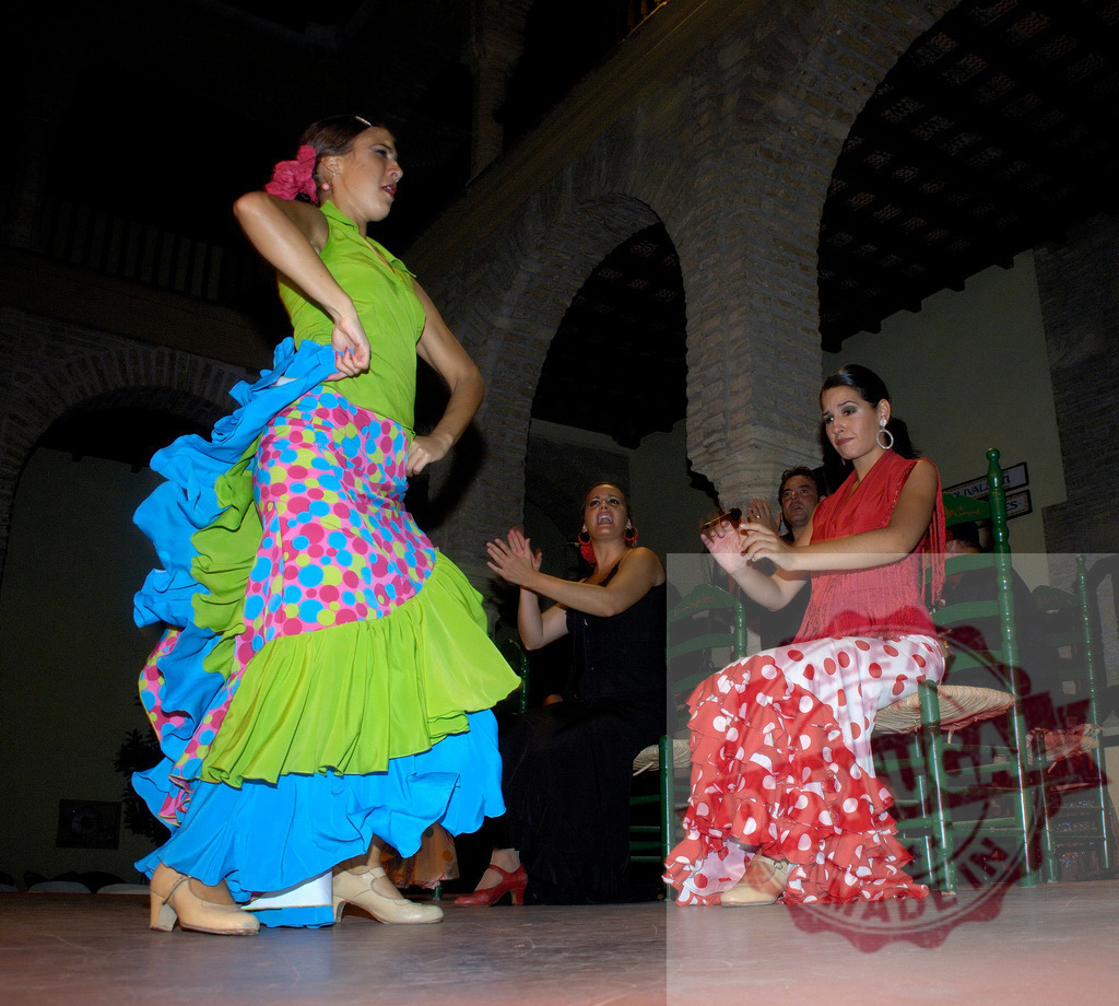 Flamenco dancers performing traditional Spanish culture on stage | Flamenco dancers performing traditional rhythmic clapping and expressive movements in cultural authentic attire - Realisiert mit Pictrs.com