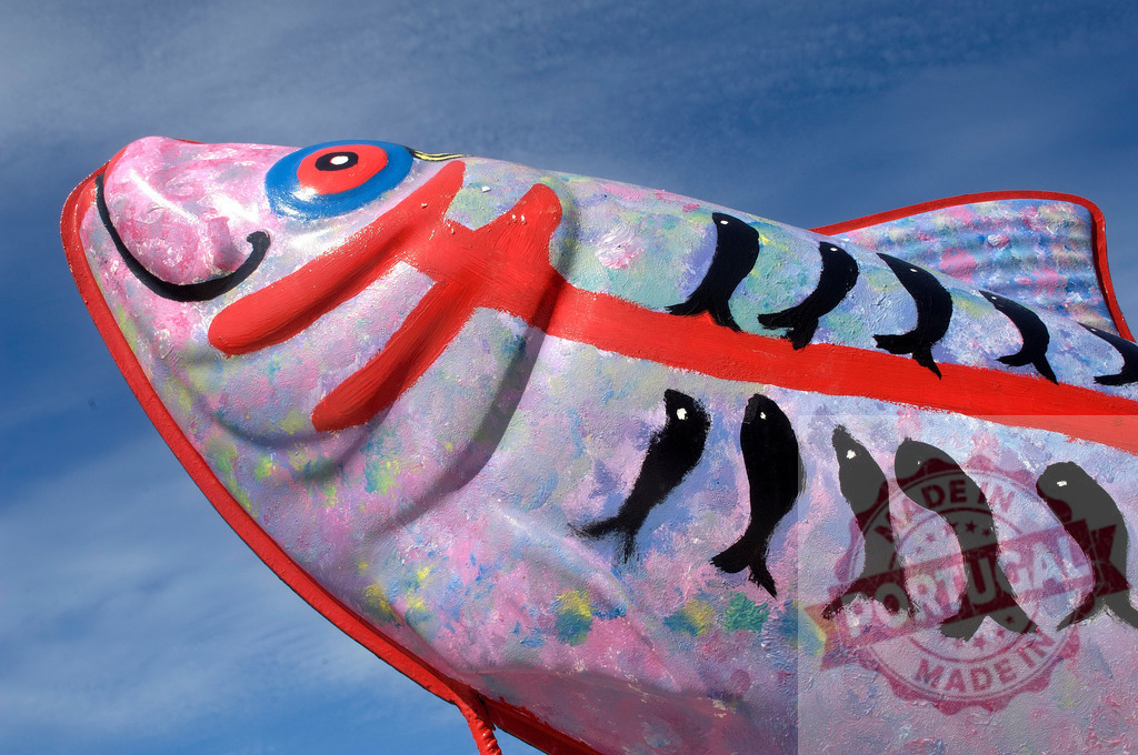 Large colorful fish sculpture against blue sky | Large painted fish sculpture presenting vibrant folk art colors and abstract patterns - Realized with Pictrs.com