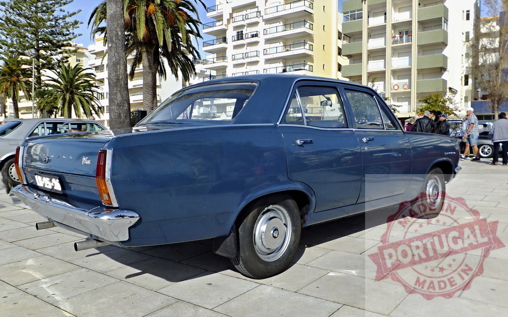 Classic Vauxhall Victor FC 101 Deluxe parked near palm trees and buildings | Shiny blue Vauxhall Victor FC 101 Deluxe parked on a paved area with palm trees and buildings in the background - Realized with Pictrs.com