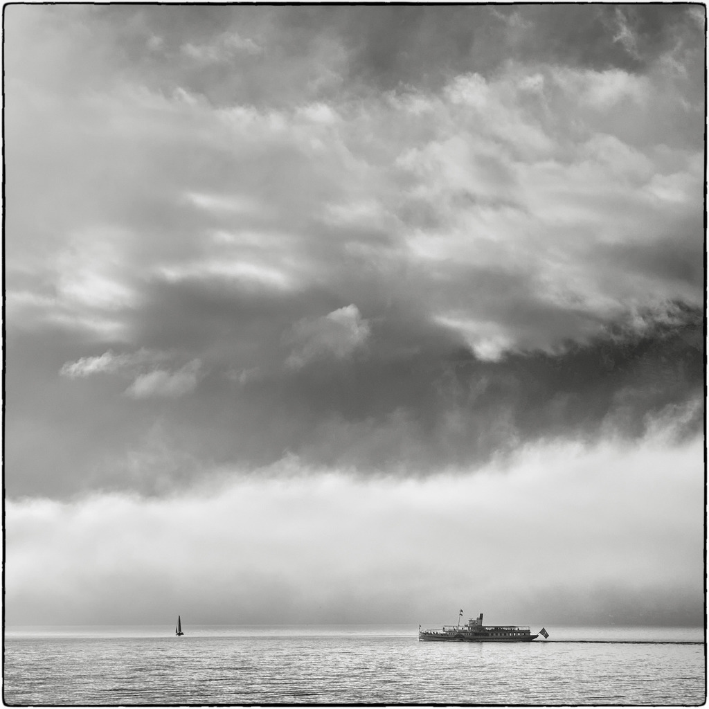 Pursuit | DS Blümlisalp scheint auf ihrer Neujahrsfahrt ein Segelschiff zu verfolgen, unterstütz von einer unheilschwangeren Wolkendecke. 
-----------------------------------------------
DS Blümlisalp seems to be chasing a sailing ship on its New Year's voyage, supported by an ominous cloud cover.
-----------------------------------------------
Dieser Druck ist in einer limitierten Auflage von 5 Exemplaren erhältlich. 
This print is available in a limited edition of 5 copies. 
http://art.hess.photography/38-pursuit.html - Realisiert mit Pictrs.com