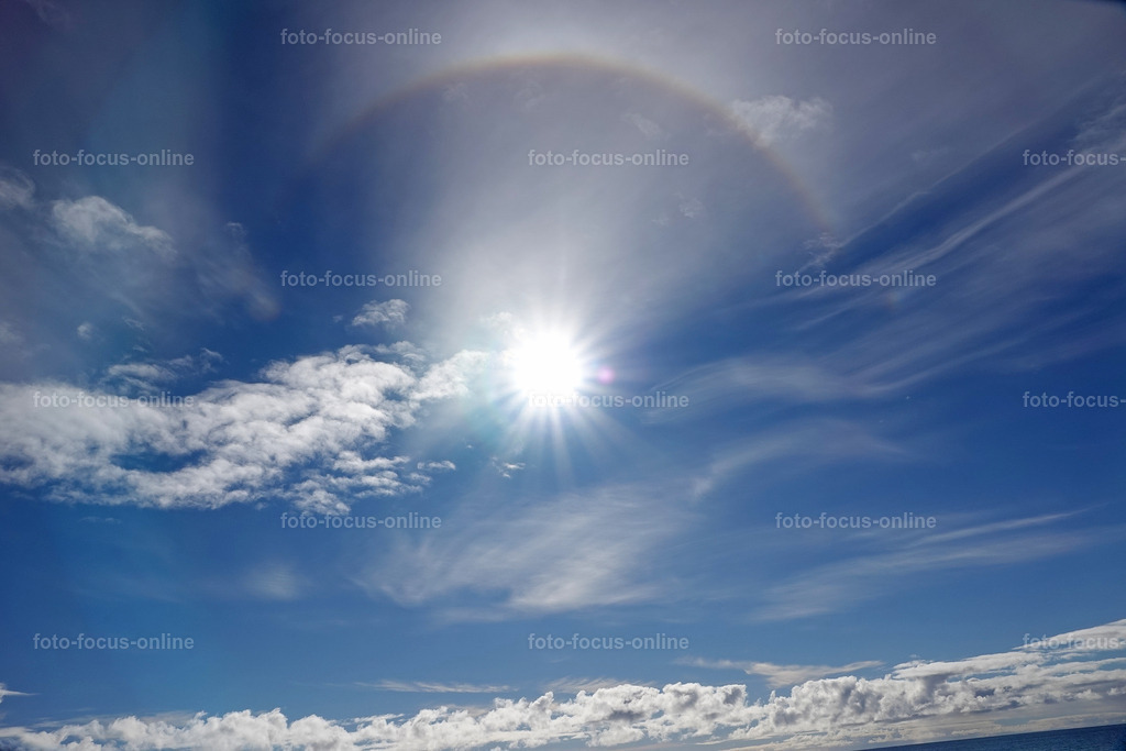 Halo-Effekt 2 | A halo effect around the sun is anoptical phenomenon in the atmosphere that appears as a bright ring or colored arc around the sun. It is caused by the refraction and reflection of sunlight by ice crystals in high cirrus clouds.