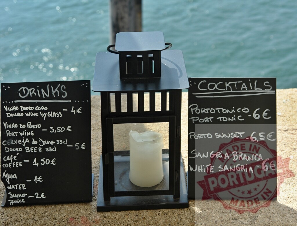 Chalkboard bar menu with drinks cocktails next to Douro river. Aveiro - Portugal | Chalkboard menus showing drinks and cocktails with a lantern candle by the Douro river - Realized with Pictrs.com